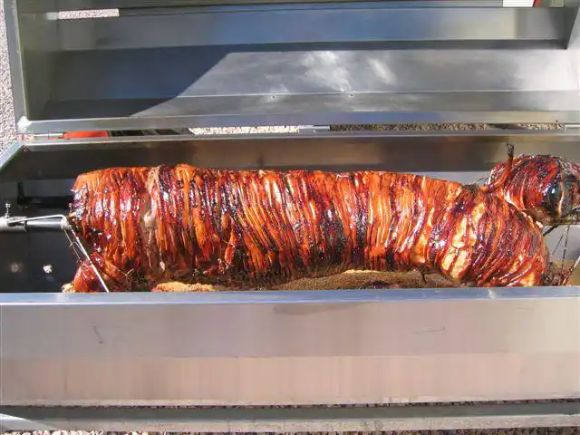 Spit roast hog being carved at an event in Devon